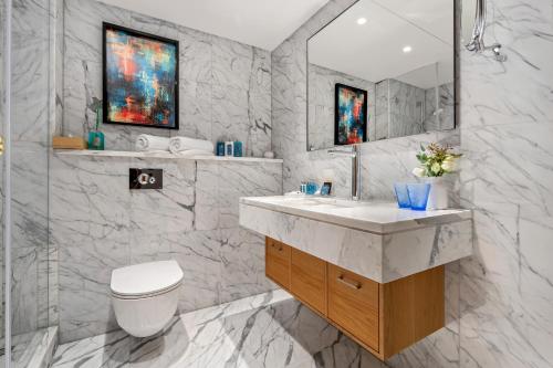 a bathroom with a sink and a toilet and a mirror at Royal Beach Eilat by Isrotel Exclusive in Eilat