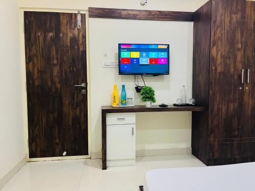 una camera con TV a parete e porta di MyWorkStay BTM a Bangalore