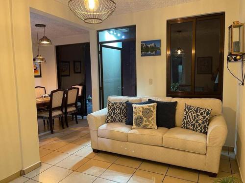 a living room with a couch and a dining room at Casa en Residencial Privado Lomas de San Francisco in San Salvador