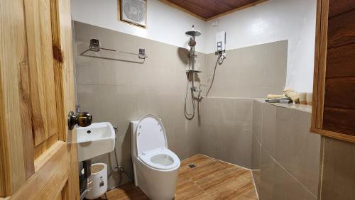 a bathroom with a toilet and a sink at Wood and Mountain in Baguio