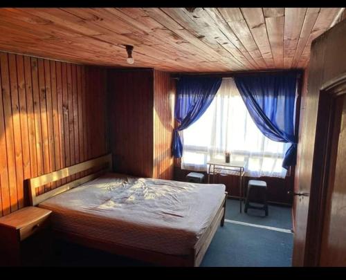Schlafzimmer mit einem Bett mit Holzdecke und einem Fenster in der Unterkunft Pensión Las Salinas in Talcahuano