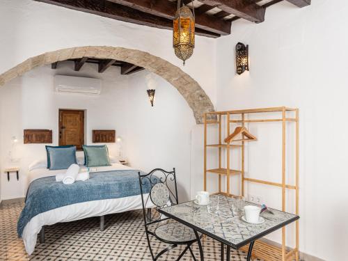 a bedroom with a bed and a table at Casa Lunarito in Vejer de la Frontera