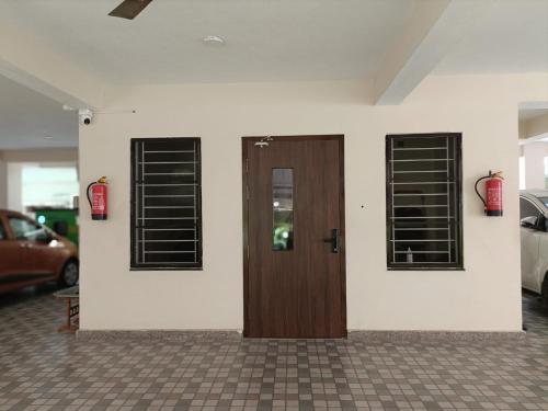 a wooden door on a white wall with three windows at Sukrithi Premium Serviced Apartment - F2 in Chennai