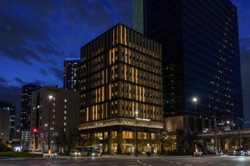 a tall glass building in a city at night at Premier hotel -CABIN PRESIDENT- Tokyo in Tokyo