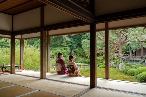 京都的住宿－OMO3 Kyoto Toji by Hoshino Resorts，两个和服的女人站在窗子外面