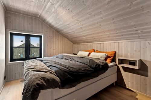 uma cama num quarto com tecto em madeira em Nedre-Hydla 38 Premium em Stryn