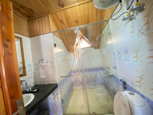 a bathroom with a shower and a sink at Himalayan Ecstacy in Manāli