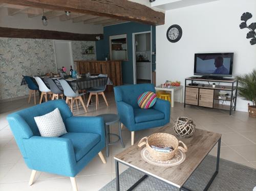 - un salon avec deux chaises bleues et une table dans l'établissement Gîte La Grange 9 pers, à Saint-Georges-sur-Cher