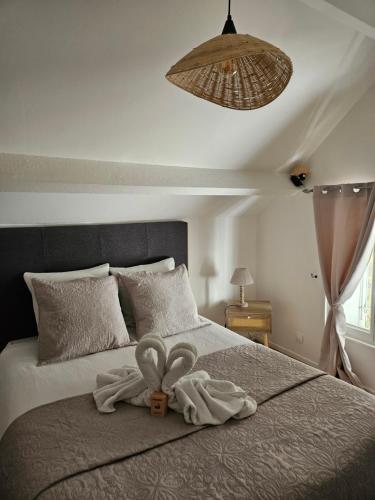 ein Schlafzimmer mit einem Bett mit zwei Handtüchern darauf in der Unterkunft La Petite Maison Romantique Giverny 5km in Bennecourt