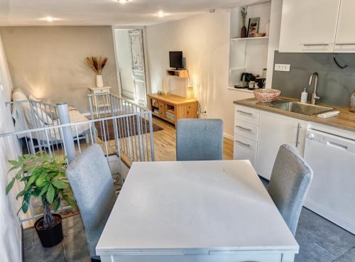 a kitchen with a white table and chairs at Gîte dans Bastide Provençale, Piscine & Sauna in Auriol