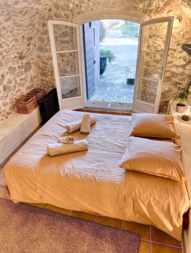 - un lit dans une chambre avec 2 serviettes dans l'établissement Gîte dans Bastide Provençale, Piscine & Sauna, à Auriol