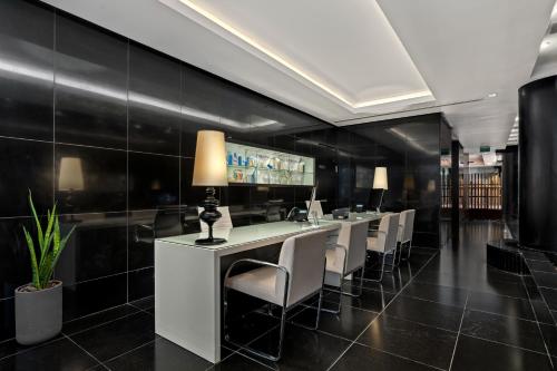 a restaurant with a long bar with white chairs at Royal Beach Eilat by Isrotel Exclusive in Eilat