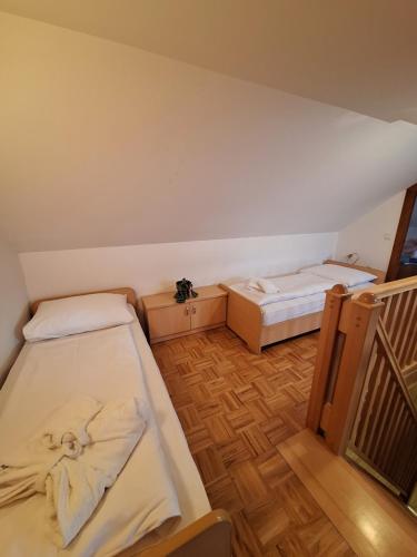 a small room with two beds and a staircase at Župnijski apartmaji in Dolenjske Toplice