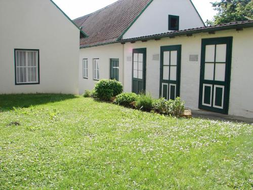 a white house with black windows and a yard at Bioweingut Hauerhof 99 -apartment 2 in Klosterneuburg