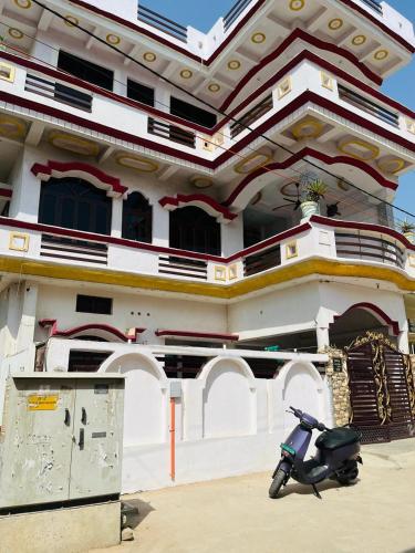 einem Roller, der vor einem Gebäude geparkt ist in der Unterkunft Shri SeetaRam Home Stay Near Shri Ram Janmabhoomi Mandir Ayodhya in Ayodhya