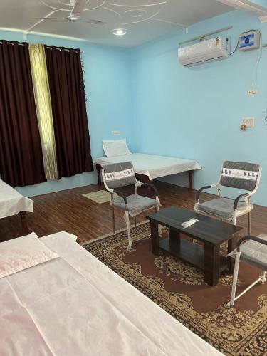 una habitación de hospital con 2 sillas y una mesa en Shri SeetaRam Home Stay Near Shri Ram Janmabhoomi Mandir Ayodhya, en Ayodhya