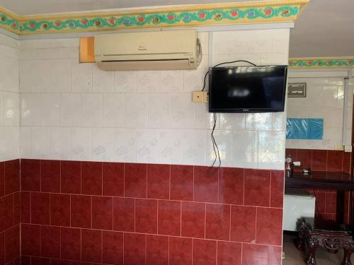 a television on the wall of a bathroom at Ditar Guest House D in Battambang