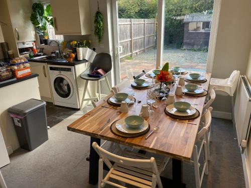 a kitchen with a wooden table with plates on it at Brislington villa in Bristol