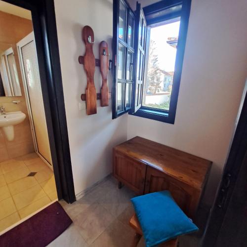 ein Badezimmer mit einer Holzbank und einem Fenster in der Unterkunft Aura house in Dolna Banya