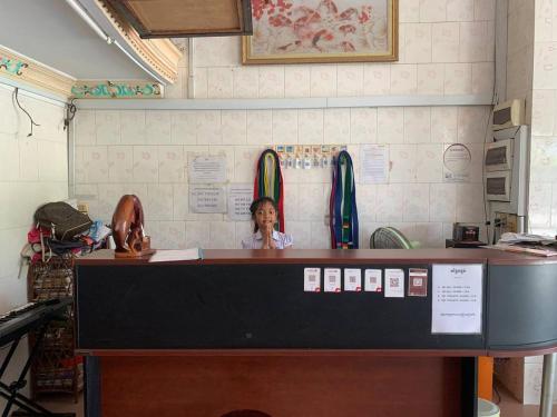 a woman sitting at a counter in a restaurant at Ditar Guest House D in Battambang
