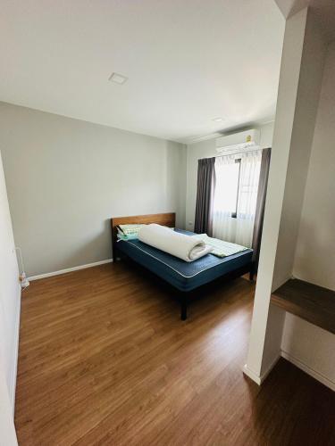 a bedroom with a bed in a room with a window at Malada in Chiang Mai