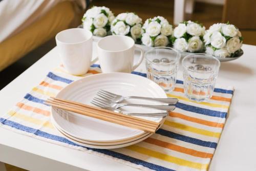 a table with plates and utensils and a tray of flowers at Diamante Yakuin - Vacation STAY 71963v in Fukuoka