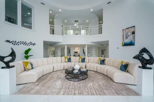 a large living room with a white couch and a table at 9000 SF Waterfront Mansion Pool Boat Dock Theater in Fort Pierce