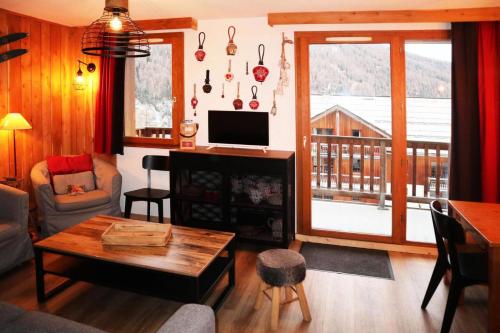 un salon avec un canapé, une table et une télévision dans l'établissement Les Chalets De Bois Mean - A201 LES CHALETS DE BOIS MEAN : Résidence de standing MAE-0804, aux Orres