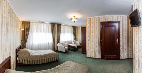 ルブリンにあるKompleks restauracyjno-noclegowy Rubikonのベッドとテレビ付きのホテルルーム
