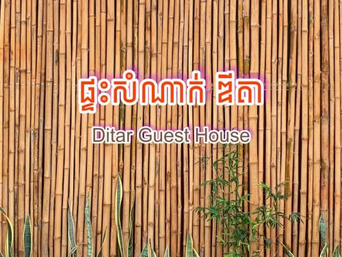 a sign on the side of a bamboo fence at Ditar Guest House D in Battambang