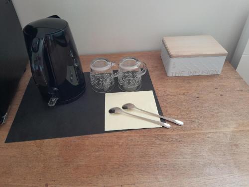 a wooden table with two glasses and a box at La côte des Blancs - Domaine viticole & maison d'hôtes in Vinzelles
