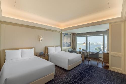 a hotel room with a bed and a table at The Ritz-Carlton, Harbin in Harbin