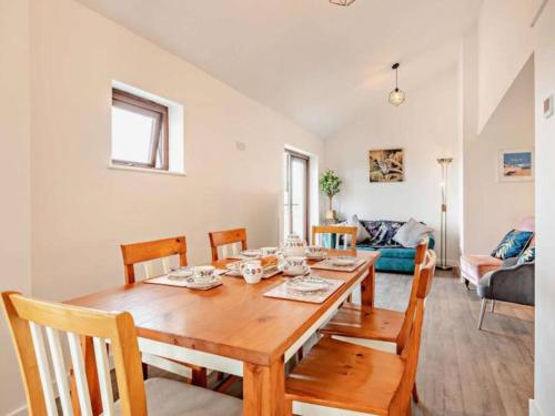 uma sala de jantar com uma mesa de madeira e cadeiras em Huntington - 4 berth renovated barn em Combe Martin