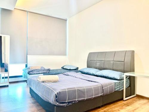 ein Schlafzimmer mit einem großen Bett mit blauen Kissen in der Unterkunft Jeff & Ricky Homestay107 @Viavacity Apartment in Kuching