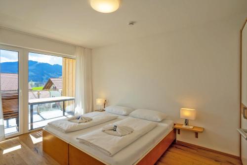 a large bed in a room with a large window at Fewo Marca in Oy-Mittelberg