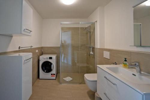 een badkamer met een wasmachine en een wasmachine bij Fewo Marca in Oy-Mittelberg