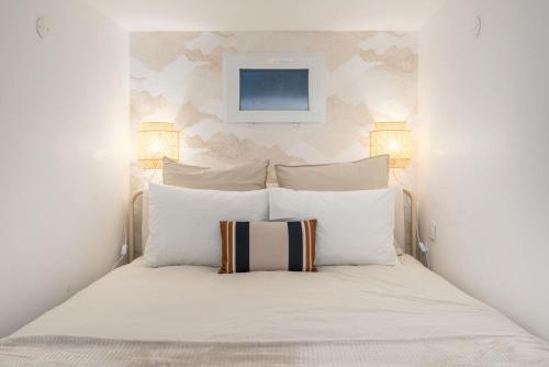 a bedroom with a white bed with white pillows at Le Cocon Traboule & SPA in Lyon