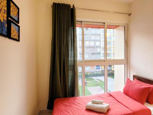 a bedroom with a red bed and a window at No Fixed Address in Marmagao
