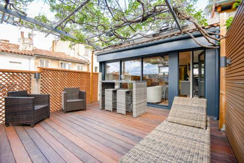 une terrasse extérieure avec des chaises et des tables sur un bâtiment dans l'établissement La Terrasse Ricard - Belle maison 1 ch avec clim, à Marseille