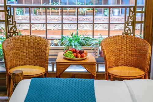 麗江市にある思法特观景客栈 Sifat Viewing Innの椅子2脚付きのテーブルに果物を盛り付けます。