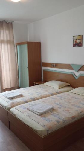 a bedroom with two beds with towels on them at Hotel Diva in Ravda