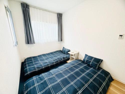 a bedroom with two beds and a window at Akikawa Koshi 2 in Yuge