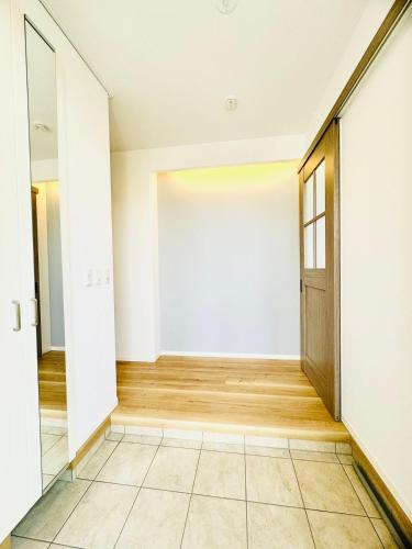 an empty hallway with a door and a tiled floor at Akikawa Koshi 2 in Yuge