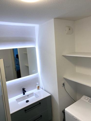 une salle de bain avec un lavabo et un miroir dans l'établissement Rez de Jardin T3 recent et calme au Nouvelles Terres à La Londe les Maures, à La Londe-les-Maures