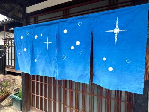 uma cortina azul sobre uma cerca com uma estrela sobre ela em Hoshikuzu em Naoshima