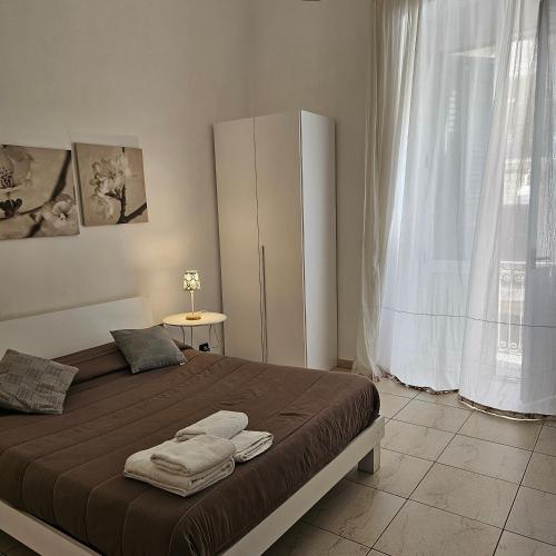 1 dormitorio con cama y ventana grande en Appartamento con 2 camere, en Taranto