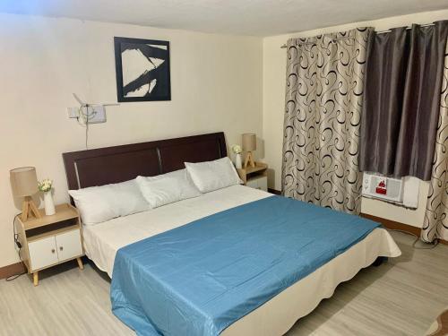 a bedroom with a large bed with a blue blanket at TraveLodge in Cainta