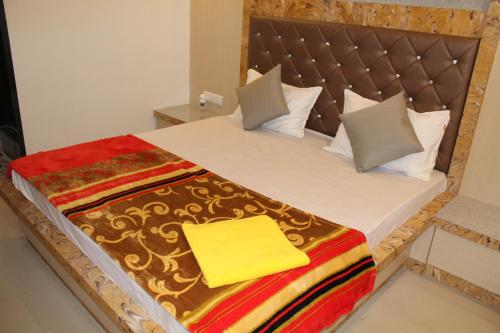 łóżko z kocem i poduszkami w obiekcie Hotel Skylark w mieście Vapi