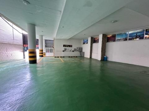 um quarto vazio com um piso verde num edifício em Queen motel em Tongyeong