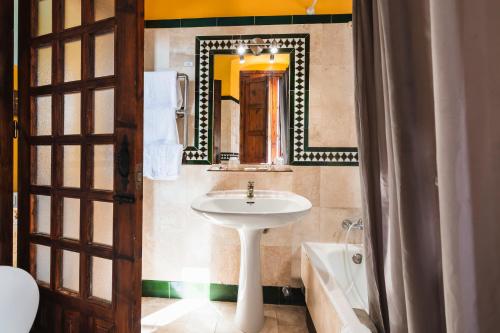 a bathroom with a sink and a mirror and a tub at Hotel Balneario De Sierra Alhamilla in Pechina